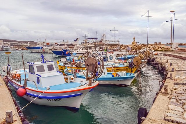 Brightly painted wooden fishing boats moored in the harbour at Ayia Napa.