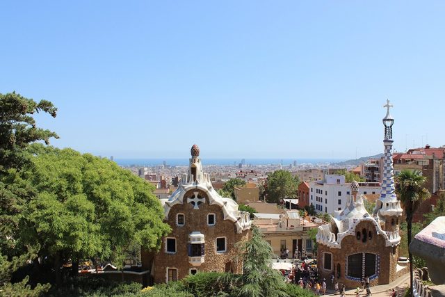 Park Guell looking over Barcelona to the sea, Gaudi's tiled pavilions in front.