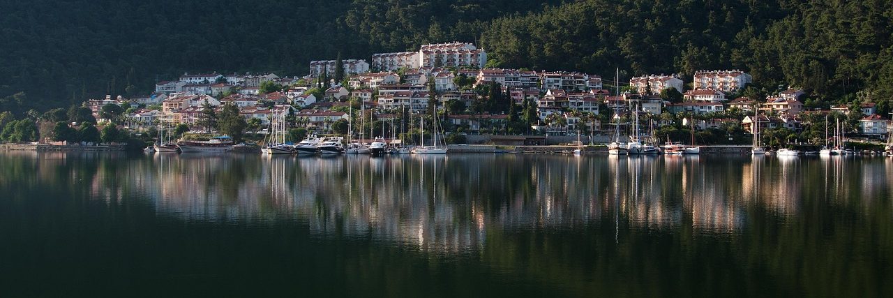 Fethiye spread along the far shore of its still bay, boats moored off the town and wooded hills rising behind it.