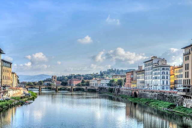 The Arno between its embankments in Florence, ochre buildings along both banks.