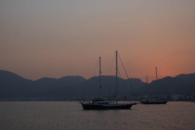 Wooden gulets at anchor off Marmaris at dusk, mountains behind.
